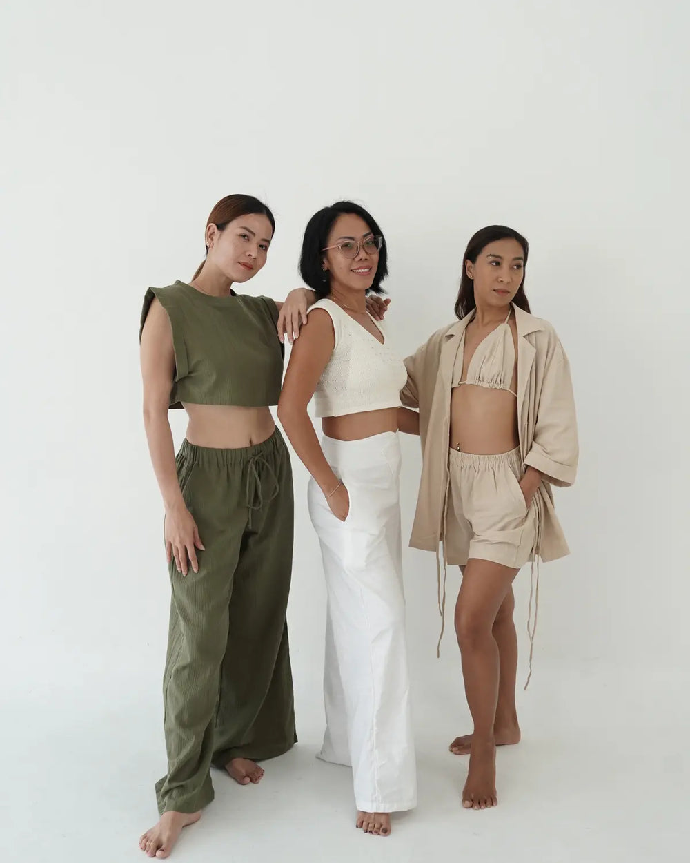Three women wearing linen different outfits on a white background